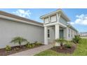 Home exterior featuring manicured landscaping, blue door, and tile roof at 12520 Brookgreen St, Venice, FL 34293