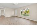 Bright and airy living room featuring sleek wood floors, a large window, and freshly painted walls at 2070 Carpetgreen St, Port Charlotte, FL 33948
