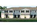 Charming townhome exterior showcasing a blue and grey facade, a one car garage, and beautifully landscaped front yard at 2469 Mellow Ln, Clearwater, FL 33765