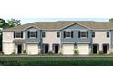 Charming townhome exterior showcasing a blue and grey facade, a one car garage, and beautifully landscaped front yard at 2469 Mellow Ln, Clearwater, FL 33765