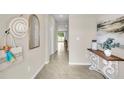Inviting entryway with neutral tones, decorated with a decorative hat, mirror, and table at 2477 Mellow Ln, Clearwater, FL 33765