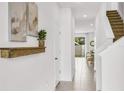 Bright entryway featuring neutral walls, a wood accent shelf, and stairs leading to the upper level at 2481 Mellow Ln, Clearwater, FL 33765