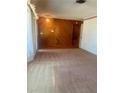 Spacious living room featuring paneled walls, large window, and neutral carpet at 2712 52Nd Avenue W Ter, Bradenton, FL 34207