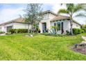 Inviting one-story home boasts mature landscaping and a well-maintained lawn, creating a welcoming curb appeal at 27454 Hole In One Pl, Englewood, FL 34223