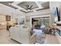 Open concept living room connects to the outdoor pool area through sliding glass doors and the kitchen at 27454 Hole In One Pl, Englewood, FL 34223