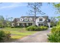 Beautiful two-story home with manicured lawn, mature trees, and a welcoming entrance at 30416 Saddlebag Trl, Myakka City, FL 34251
