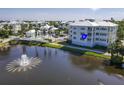 Charming view of condo building, a pool with lounge chairs, and a tranquil pond with a fountain at 3420 77Th W St # 202, Bradenton, FL 34209