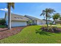 Beautifully landscaped front yard with a well-manicured lawn and flowering plants around the perimeter of this Florida home at 3725 Spyglass Hill Rd, Sarasota, FL 34238