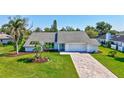 Beautiful front elevation of single Gathering home featuring mature trees, blue door, and brick driveway at 3725 Spyglass Hill Rd, Sarasota, FL 34238