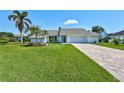 Charming single-story home featuring a lush lawn, brick driveway, and well-maintained landscaping in Venice, Florida at 3725 Spyglass Hill Rd, Sarasota, FL 34238