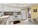 Bright kitchen featuring white cabinets, granite countertops, and modern appliances at 3917 Ashwood Ln # 57, Sarasota, FL 34232