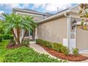 Tan home featuring a side entrance with palm trees and lush landscaping at 4021 Wildgrass Pl, Parrish, FL 34219
