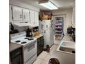 Bright kitchen featuring white appliances and ample cabinet space at 4070 Grobe St, North Port, FL 34287
