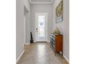 A well-lit foyer features a glass door, diagonal tile floor, and a decorative console table at 4406 Baltry Ct, Bradenton, FL 34211