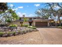 Inviting home featuring a meticulously landscaped front yard and a two-car garage at 4711 Ocean Blvd, Sarasota, FL 34242