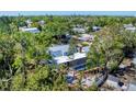 Aerial showing a serene property with a pool, fire pit, and lush trees surrounding the house at 5404 4Th Avenue Nw Dr, Bradenton, FL 34209