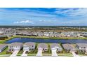 Picturesque aerial view of a residential neighborhood with a central pond and well-maintained homes at 5688 Woodland Sage Dr, Sarasota, FL 34238