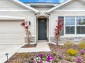 Charming front entrance with stone accents and vibrant flower beds leading to an elegant door at 5688 Woodland Sage Dr, Sarasota, FL 34238