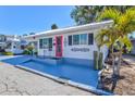 Charming home featuring a bright pink door, white exterior, and a well-maintained, painted front patio area at 7 Braden Castle Dr, Bradenton, FL 34208