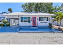Charming home showcasing a vibrant pink door, freshly painted exterior, and a blue painted driveway at 7 Braden Castle Dr, Bradenton, FL 34208