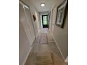 Inviting hallway featuring tile flooring, closet space, and a door leading to the outside at 7520 4Th W Ave # 1, Bradenton, FL 34209