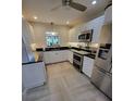 Bright kitchen featuring white cabinets, stainless steel appliances, and modern lighting at 7520 4Th W Ave # 1, Bradenton, FL 34209
