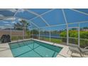 Inviting screened-in pool with clear blue water offering a refreshing oasis and a peaceful view of the surrounding lake at 7664 Camminare Dr, Sarasota, FL 34238