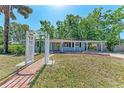 Inviting single-story home with a decorative white archway, and well-maintained landscaping at 826 Lillian Ln, Sarasota, FL 34243