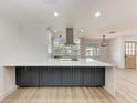 Modern kitchen featuring a large island with cooktop, contrasting cabinetry, and stylish pendant lighting at 826 Lillian Ln, Sarasota, FL 34243