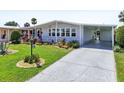 Inviting home with a well-kept lawn, colorful landscaping, and a spacious covered driveway at 8534 Imperial Cir, Palmetto, FL 34221