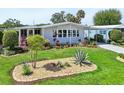 Well-maintained home showcases vibrant landscaping, manicured lawn, and a welcoming covered carport at 8534 Imperial Cir, Palmetto, FL 34221