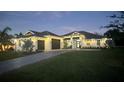 Stunning home featuring a wide driveway, two-car garage, and immaculate landscaping at dusk at 1007 143Rd Ne St, Bradenton, FL 34212