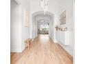 Bright hallway with arched doorways and modern light fixtures creates an inviting entry to the home at 1189 Fraser Pine Blvd, Sarasota, FL 34240