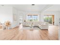 Sun-filled living room featuring tile floors, neutral décor, and sliding door access to the screened in lanai at 1189 Fraser Pine Blvd, Sarasota, FL 34240