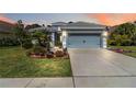 Charming single-story home featuring a well-manicured lawn, elegant landscaping, and a two-car garage at 12272 Stuart Dr, Venice, FL 34293