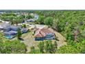 Aerial view of a home's backyard with pool, surrounded by lush trees, and a lake in the distance at 15107 3Rd E Dr, Bradenton, FL 34212