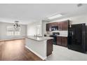 A kitchen and dining space featuring dark cabinets, an island and stainless steel appliances at 15207 Peaceful Bull Pl, Bradenton, FL 34212