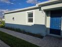 The exterior features a blue entry door, neutral siding, window with blinds and a brick walkway at 16120 Ivy Ridge Ct, Port Charlotte, FL 33953