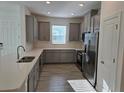 Modern kitchen with stainless steel appliances, grey cabinetry, quartz countertops, and stylish backsplash at 16120 Ivy Ridge Ct, Port Charlotte, FL 33953