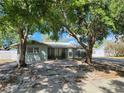 Charming single-story home with mature trees providing shade, a well-kept lawn, and a driveway at 2727 Waldemere St, Sarasota, FL 34239