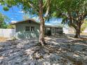 Charming single-story home with mature trees providing shade, a white fence, and a well-kept lawn at 2727 Waldemere St, Sarasota, FL 34239