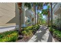 Exterior view of a two-story townhome featuring mature palms and landscaping at 275 Sapphire Lake Dr # 101, Bradenton, FL 34209