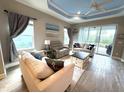 Cozy living room featuring comfortable seating, ceiling fan, and sliding doors to the lanai at 2918 Butterfly Jasmine Trl, Sarasota, FL 34240