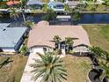 Aerial view of home with tile roof, mature landscaping, and easy access to canals and waterways at 3069 Stone St, Port Charlotte, FL 33981