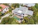 Aerial view of house showcasing private pool, patio and lush surroundings with a metal roof at 3455 Flamingo Ave, Sarasota, FL 34242