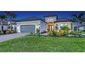 Inviting single-story home with a well-manicured lawn and beautiful landscape lighting at 3568 Santa Caterina Blvd, Bradenton, FL 34211