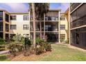 Exterior shot of the condo building with lush landscaping, plants, and lawn with views of the patio and balconies at 425 30Th W Ave # C208, Bradenton, FL 34205