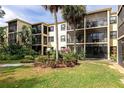 Exterior shot of the condo building with lush landscaping, plants, and lawn with views of the patio and balconies at 425 30Th W Ave # C208, Bradenton, FL 34205