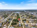 An aerial view shows the neighborhood of single-story homes and the waterways in the distance at 425 Skylark Nw Ln, Port Charlotte, FL 33952