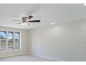 Bright living room featuring large windows, neutral paint, and a ceiling fan at 425 Skylark Nw Ln, Port Charlotte, FL 33952